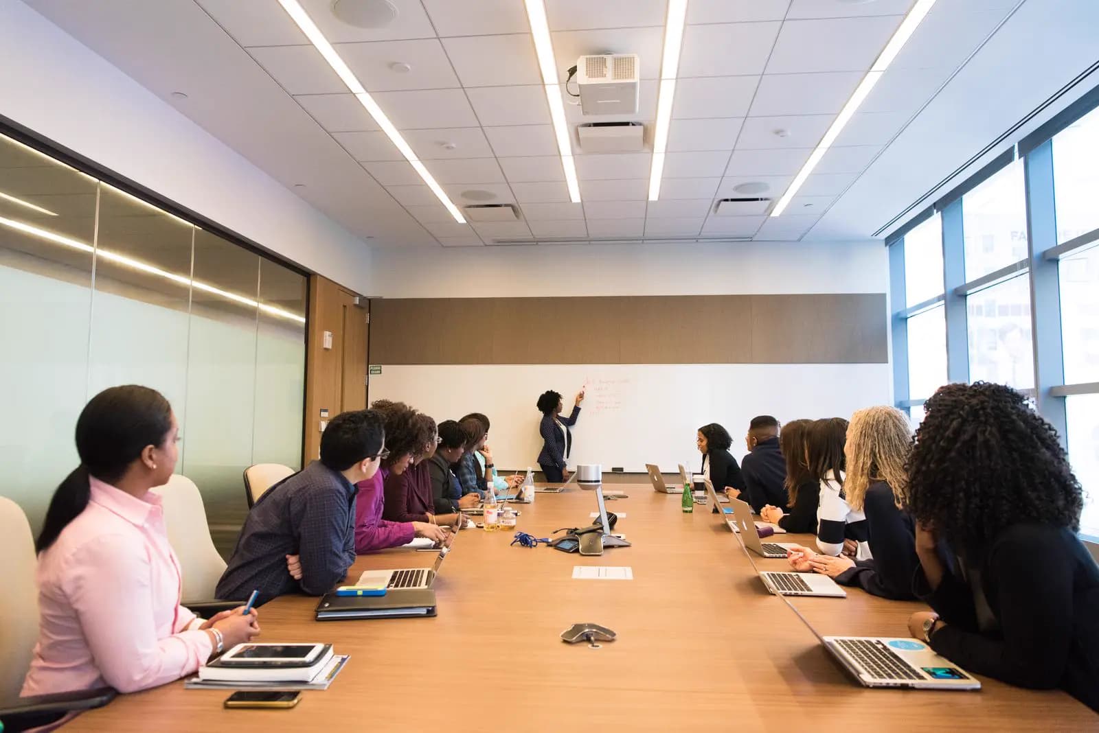 An operations team meeting with laptops open around a conference table