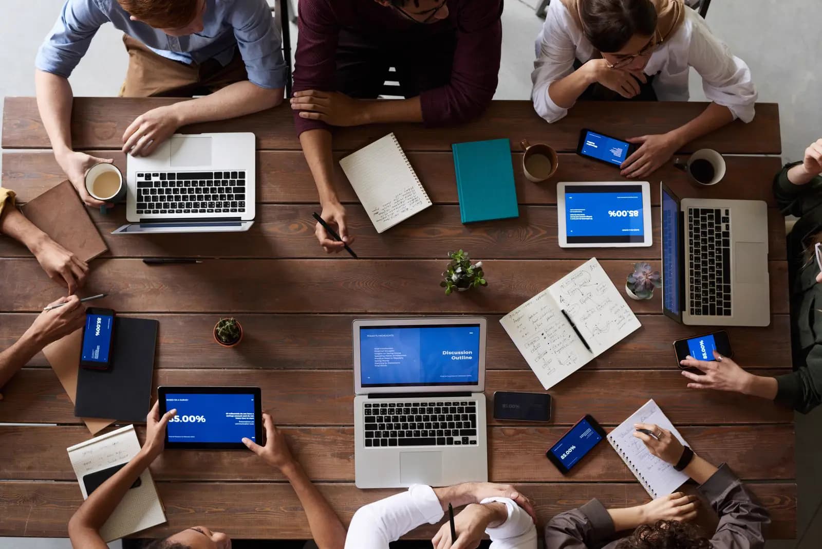 Professionals working together on laptops around a conference table